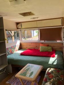 Zimmer mit einem Bett auf der Rückseite eines Wohngebäudes in der Unterkunft Unique 70s caravan, calm and relaxed in Les Cresnays