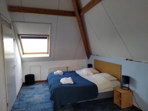 een slaapkamer met een bed met twee handdoeken erop bij De Stormvogel in Baaiduinen