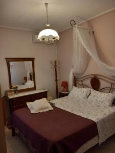 sypialnia z dużym łóżkiem i lustrem w obiekcie Poly's Sea Side House w mieście Koropi