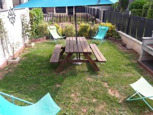 a picnic table and two chairs in a yard at L'amarante chambres d'hôtes villefranche de panat in Villefranche-de-Panat