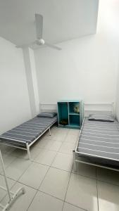 2 bedden in een kamer met een tegelvloer bij Homestay Near Plaza Tol Bandar Ainsdale in Labu