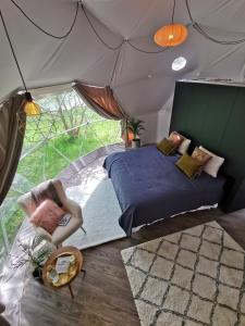 1 camera da letto in una tenda con letto e sedia di Teapot Lane Glamping - Adults only a Sligo