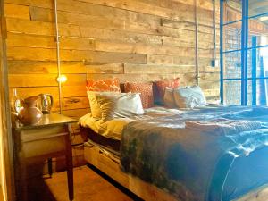 a bedroom with a bed and a wooden wall at Infinity at Enfin Estate in Nottingham Road