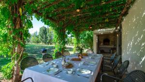 un tavolo con piatti di cibo seduti sotto un pergolato di LA CASA NEI VIGNETI 10, Emma Villas a Catignano