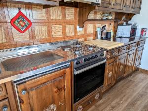 a kitchen with a stove and wooden cabinets at Alpine Vista Villa Hardaker 4 bedrooms Torgnon in Torgnon +54 photos