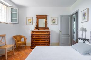una camera con letto, cassettiera e specchio di La Serra Vitignano-Stunning Villa W/Swimming Pool! a Castelnuovo Berardenga