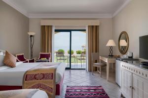 Cette chambre d'hôtel comprend un lit et offre une vue sur l'océan. dans l'établissement The Bayview Taba Heights Resort, à Taba