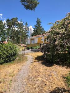 una casa con un camino de grava delante de ella en Havsnära villa, närhet till stan en Värmdö