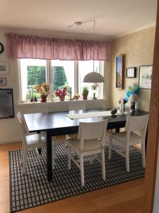 a dining room with a table and chairs and windows at Havsnära villa, närhet till stan in Värmdö