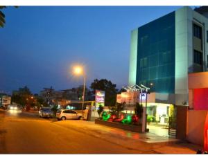 a city street at night with a building and cars at Hotel Flora Inn, Nagpur in Nagpur