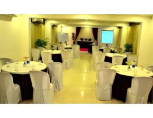 a conference room with white tables and white chairs at Hotel Flora Inn, Nagpur in Nagpur