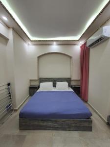 a bedroom with a large bed with a blue blanket at Saraya Eltram-families only in Alexandria +146 photos