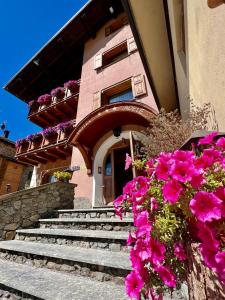 un edificio con escaleras y flores delante en Hotel Adele, en Livigno