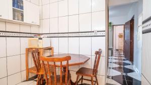 a small kitchen with a table and chairs at Apto a 300 metro da praia - WIFI 200MB - Cozinha equipada - Ar condicionado in Rio das Ostras