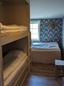 a bedroom with two bunk beds and a window at Ulvö Hamnkrog in Ulvöhamn