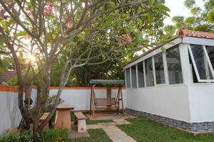 a house with a chair and a tree at Shoreside Semat Villa and Flat in Jepara