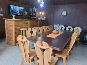 a dining room with a table and chairs and a tv at Pensiunea Daiana in Mamaia Nord