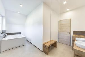 a white bathroom with a sink and a mirror at Chic Apartments with Finnish Sauna and Jacuzzi in Kranjska Gora