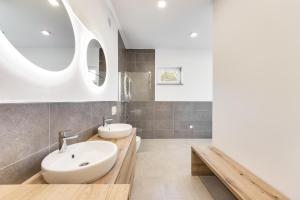 a bathroom with two sinks and two mirrors at Chic Apartments with Finnish Sauna and Jacuzzi in Kranjska Gora