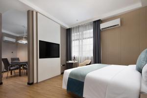 a hotel room with a bed and a television at Unitour Hotel, Xiangxiang Dongfeng Square in Xiangxiang
