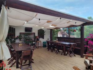 a patio with wooden tables and chairs under awning at Pensiunea Daiana in Mamaia Nord
