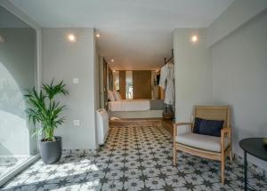 a room with a bedroom with a bed and a chair at Pafsilipon Suites in Ermoupoli +37 photos