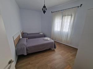a small bedroom with a bed and a window at Casas Miramar in Tarifa
