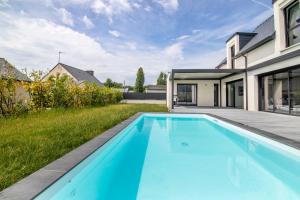 uma piscina no quintal de uma casa em Superbe Villa au Calme avec Piscine Chauffée à 5 min de la Plage de Penvins em Sarzeau