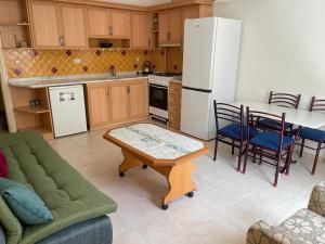 a kitchen with a couch a table and a refrigerator at Rent 1 bed in amazing complex CC in Didim