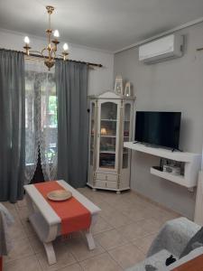salon ze stołem i telewizorem w obiekcie Poly's Sea Side House w mieście Koropi