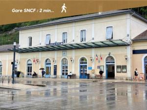 un edificio bajo la lluvia con gente caminando delante de él en La Petite Parenthèse Vienna Authentica, en Vienne