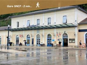 a building in the rain with people walking in front of it at La Petite Parenthèse Vienna Authentica in Vienne