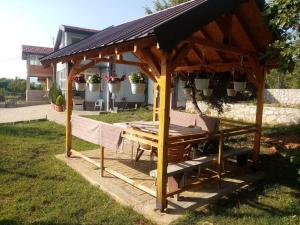 a wooden pavilion with a picnic table in a yard at Mountain Villa Petkoski in Ohrid