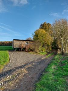 a dirt road leading to a barn on a farm at La Bucolique de Tahier in Ohey