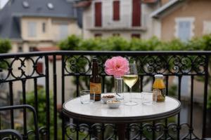 a table with a bottle of wine and glasses on a fence at Hôtel & Espace Bien-être La Maison du Lierre in Biarritz