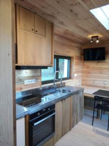 a kitchen with a sink and a stove at La Bucolique de Tahier in Ohey