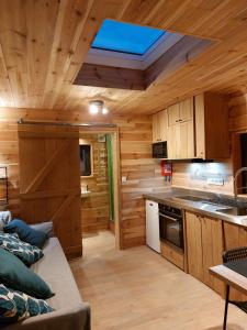 a kitchen with wooden walls and a ceiling with a skylight at La Bucolique de Tahier in Ohey