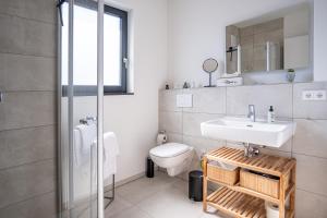 uma casa de banho com um lavatório e um WC em KEEP Business Suite H66-2 nahe Audi & Schwarz Gruppe mit Balkon, Netflix & Parkplatz em Oedheim