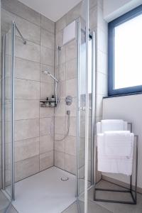 a shower with a glass door in a bathroom at KEEP Business Suite H66-2 nahe Audi & Schwarz Gruppe mit Balkon, Netflix & Parkplatz in Oedheim