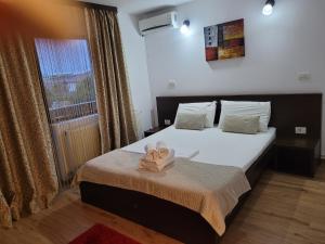 a bedroom with a bed with towels on it at Pensiunea Daiana in Mamaia Nord