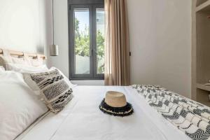 a straw hat sitting on top of a white bed at Nikole cottage house by the sea in Kokkini Khanion