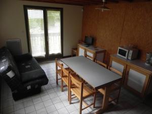 - un salon avec une table, une chaise et un four micro-ondes dans l'établissement Camping Le Castella, à Luzenac