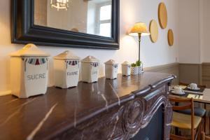 a table with four trash cans on top of it at Hôtel & Espace Bien-être La Maison du Lierre in Biarritz