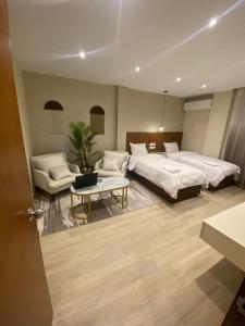 1 Schlafzimmer mit 2 Betten, einem Sofa und einem Tisch in der Unterkunft Nakhil Inn Residence in Kairo