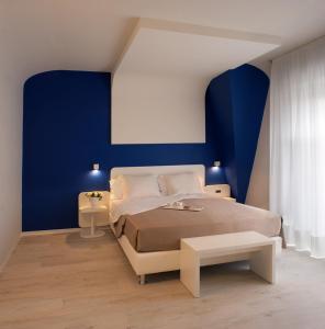 a bedroom with a bed and a blue wall at Hotel Magic in Riccione