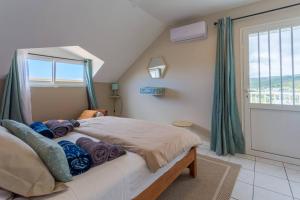 a bedroom with a large bed with a window at Le Grand Badamier Blanc grande villa familiale 5 étoiles piscine chauffée 17 personnes in Saint-Paul +39 photos