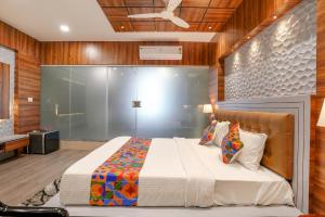 1 dormitorio con 1 cama grande y paredes de madera en FabHotel The Valentine, en Surat