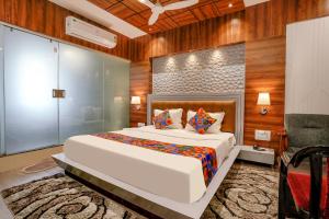 1 dormitorio con 1 cama blanca grande y paredes de madera en FabHotel The Valentine, en Surat
