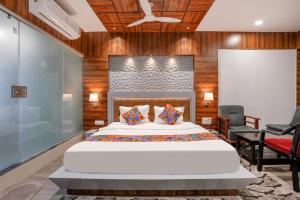 1 dormitorio con 1 cama blanca grande y paredes de madera en FabHotel The Valentine, en Surat