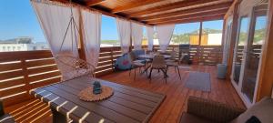 a wooden deck with a table and chairs on a balcony at Green Turtle Holiday - Lovely, brand new holiday home near the sea in Drage
